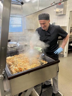 Kocken Micke i ett ångmoln från stekbordet