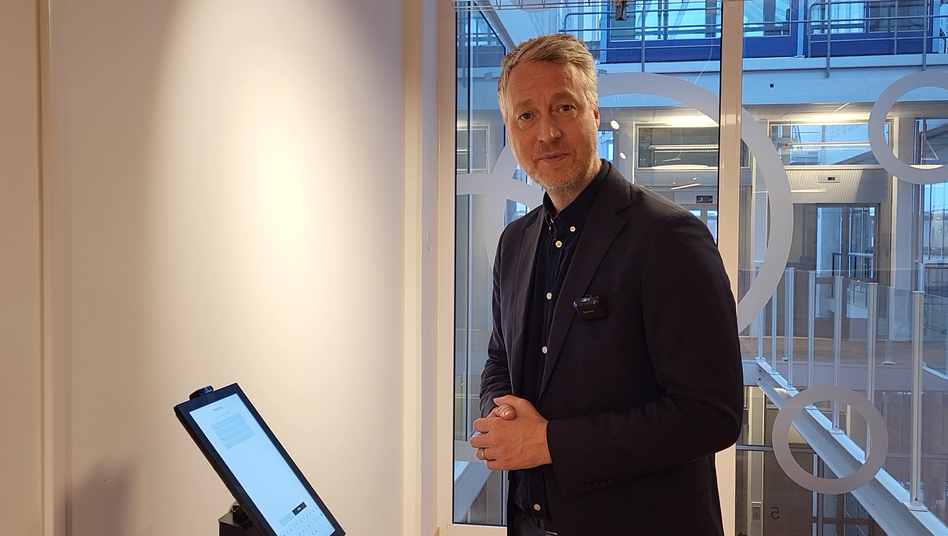 Petter står vid en skärm i receptionen