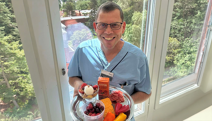 Mikael Karlsson håller i bricka med olika mellanmål.