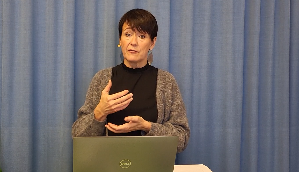 Johanna Joneklav en mörkhårig kvinna med silverlöv som örhängen gestikulerar.