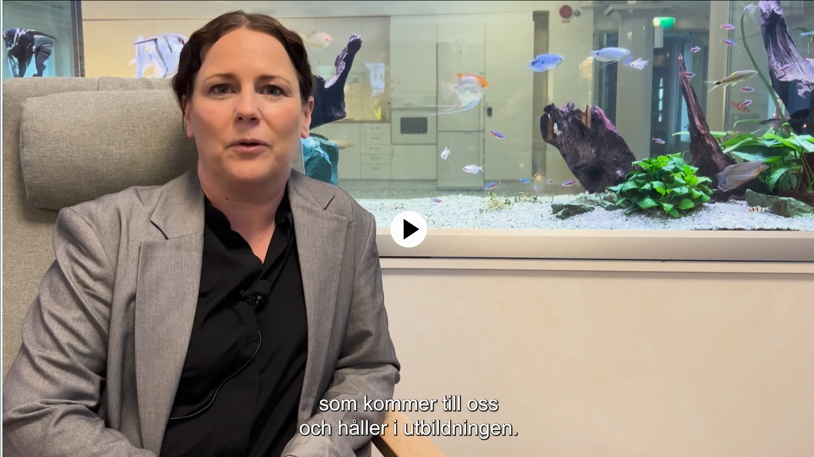 En kvinna sitter framför ett akvarium