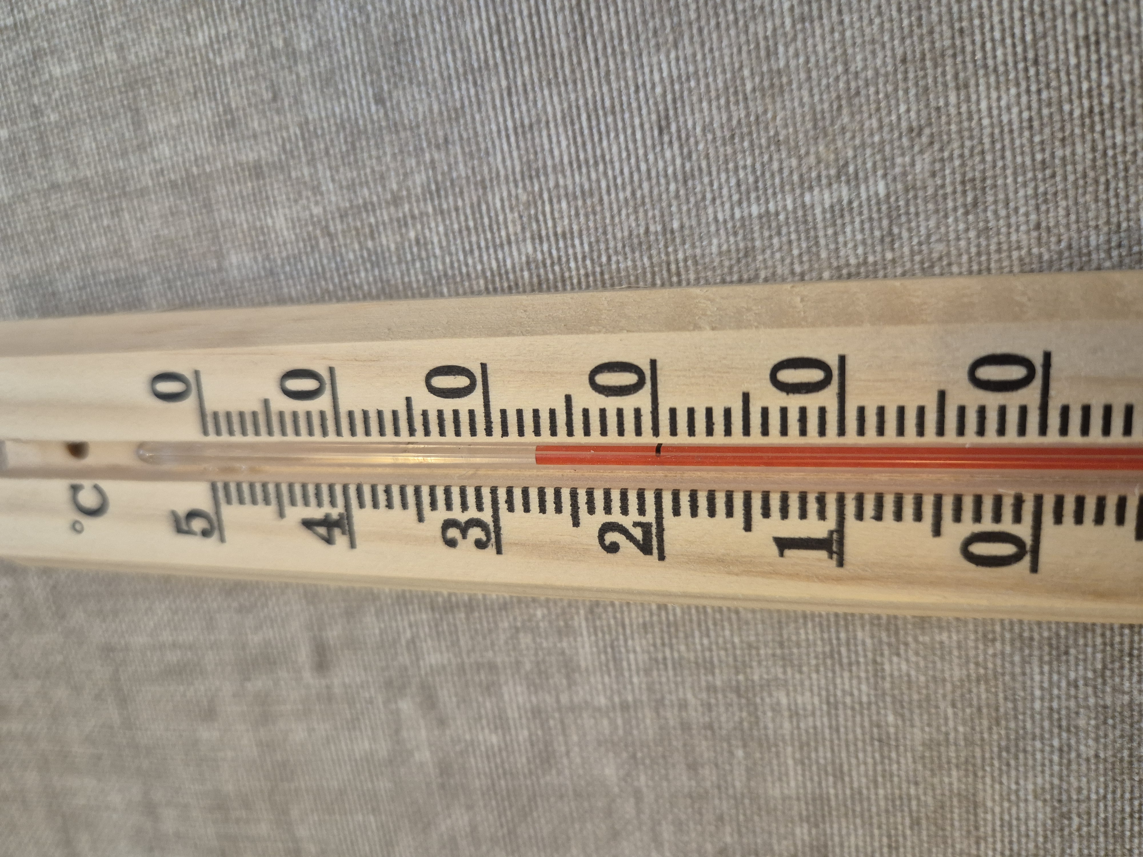 Termometer i trä som visar en temperatur på 27 grader